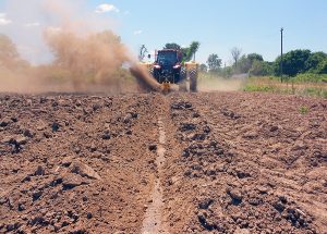 Ditcher in field digging trench