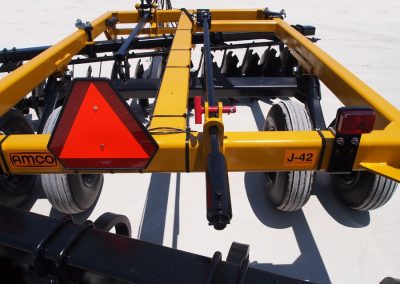 Closeup of J42 Wheel Offset Harrow hydraulic cylinder and safety emblem