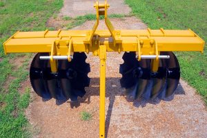 Full view of Border Plow folded on dirt and grass