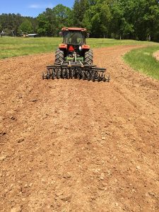 LTF Lift Offset Harrow in the field with red tractor