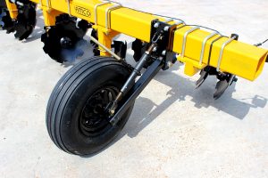 Closeup of wheel on 6-row toolbar with bedding hipper assemblies