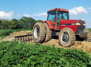 Terracing Plow in field with red tractor