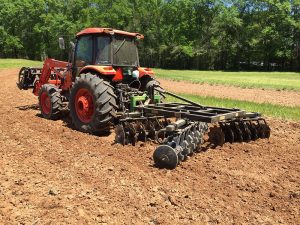 LTF Lift Offset Harrow in field with red tractor