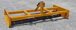 grader blade sitting on gravel