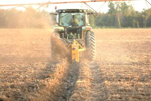 Full view of Dominator Vertical Rotary Ditcher in the field with tractor