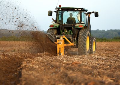 Full view of Dominator Vertical Rotary Ditcher in the field with tractor