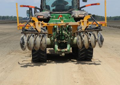 Full view of AMCO LJ6 Levee Plow being transported on the back of a green tractor