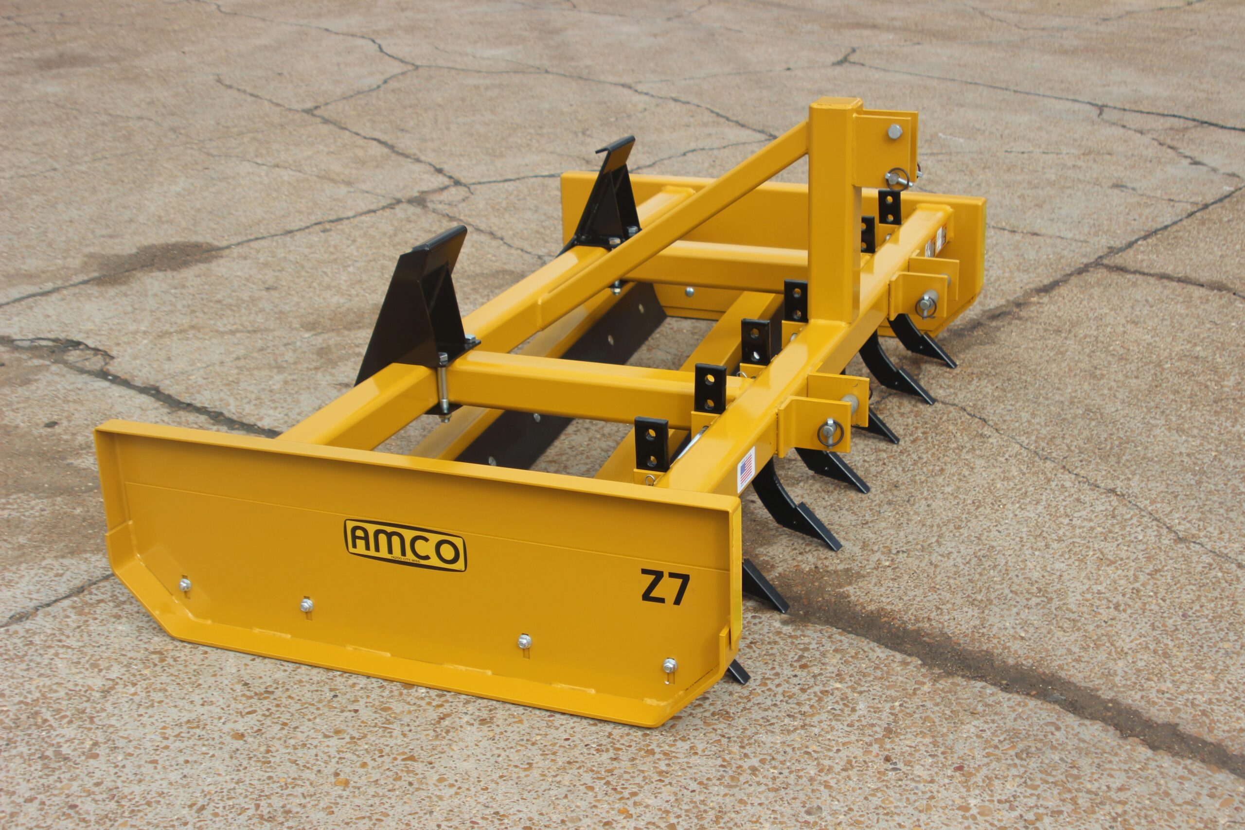 Side of Z-7 on the AMCO lot with skid steer universal adapter and scarifiers