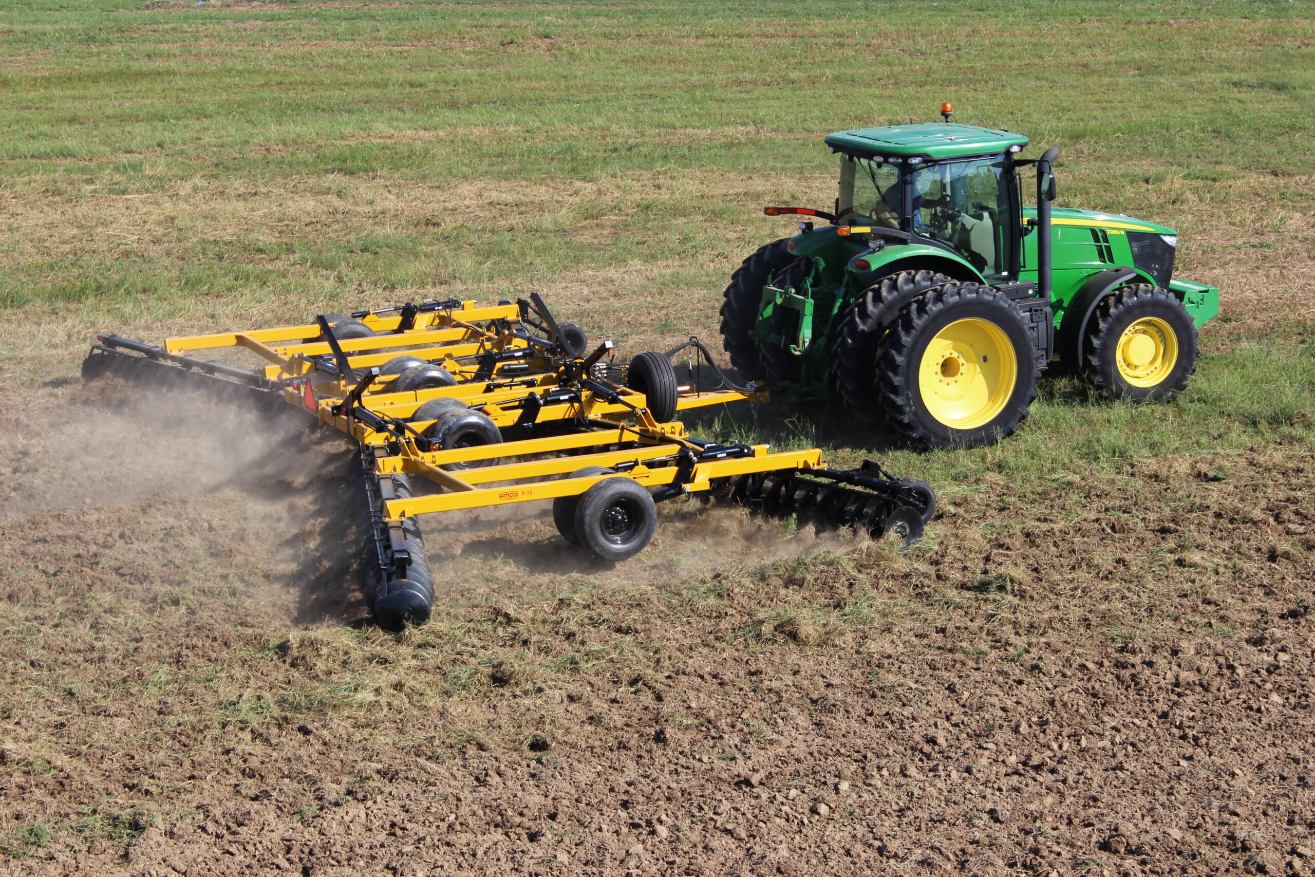 AMCO F15 Double Offset Tandem Disc Harrow running behind a John Deere tractor